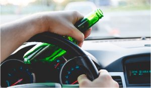 Man drinking behind the wheel of a car